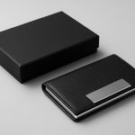 A sleek black wallet and its matching gift box on a gray background.